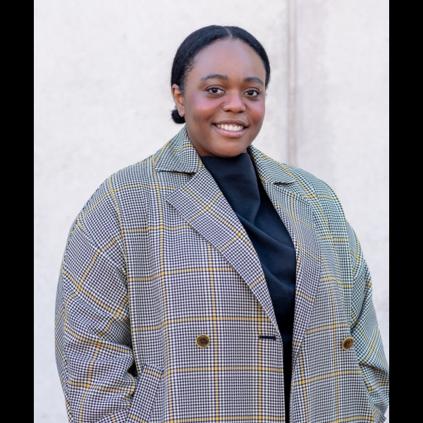 A woman in a grey coat smiling