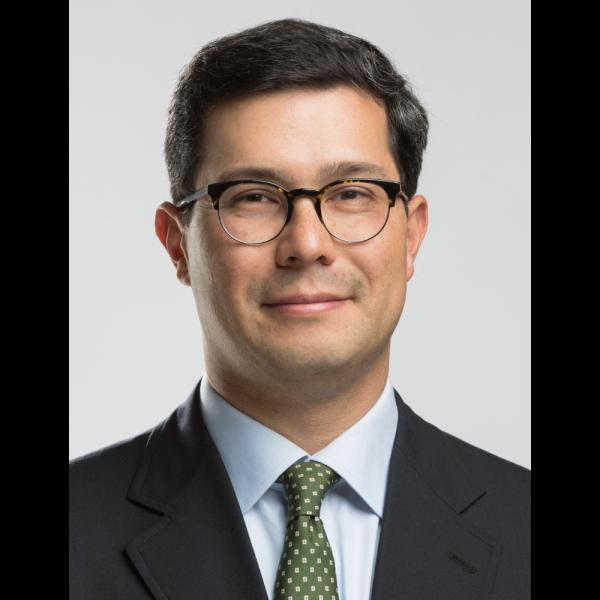 Photo of man in a green tie wearing glasses smiling