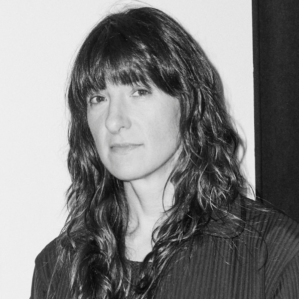 A woman with long brown hair in a black shirt 