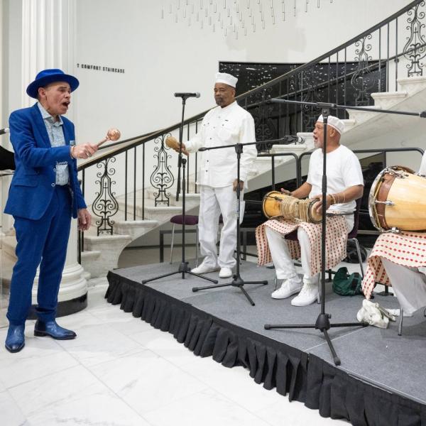Manny Vega performs with a band of musicians.