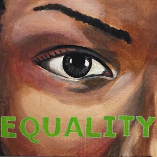 Close-up of a painting of a woman’s eye, with the word “EQUALITY” written in green beneath it 