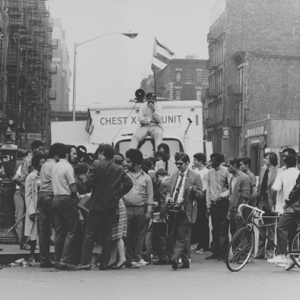 Young Lords의 일원이 East Harlem 거주자에게 무료 결핵 검사를 제공하기 위해 캠페인을 진행하는 동안 흉부 -X 레이 유닛 트럭 위에 앉아 있습니다.