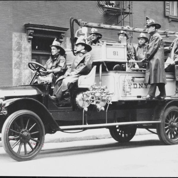 Firemen on a fire engine from the early 1900s