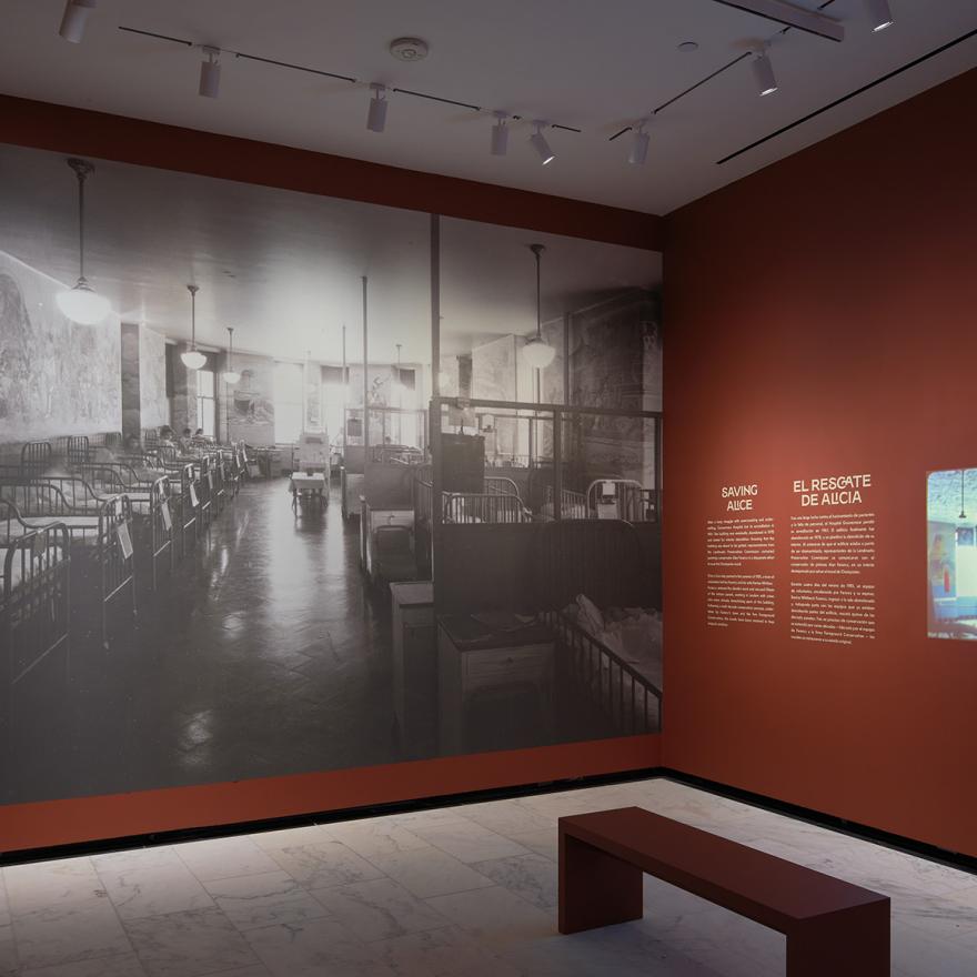 A large reproduction of a black and white photograph of a hospital interior, next to a projected video.