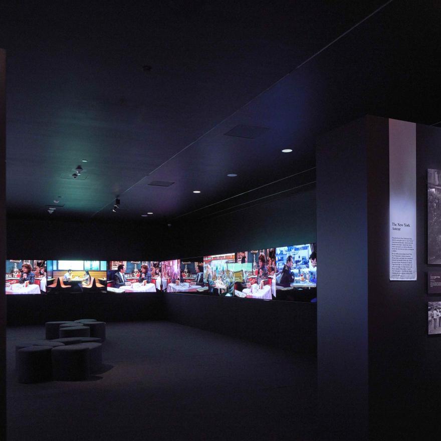 A dark room with several large screens. 