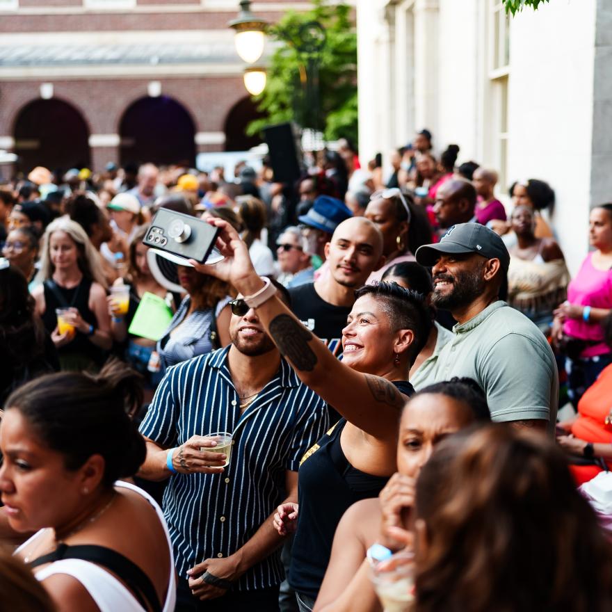A crowd of people outside of the Museum of the City of New York and four people taking a selfie.