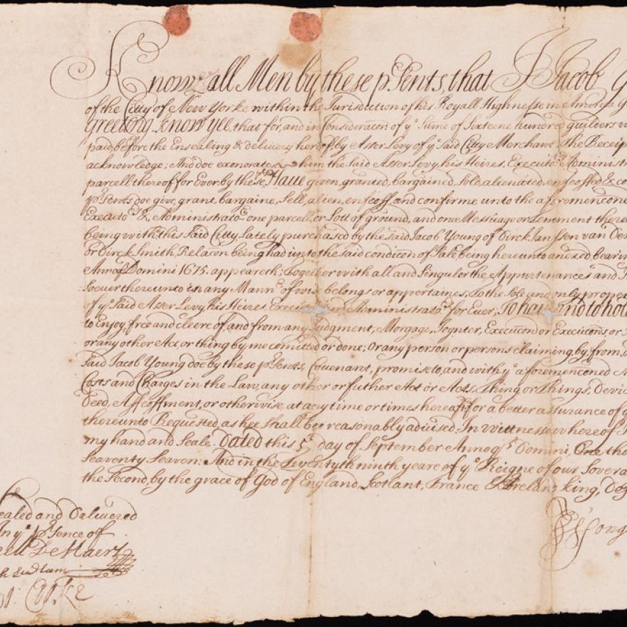 An old piece of paper with elaborate script writing and a wax seal in the bottom right corner