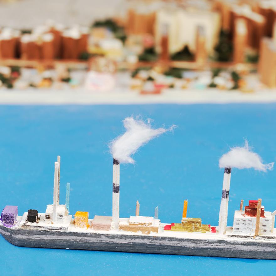 A handmade wooden boat on a scale model of New York City