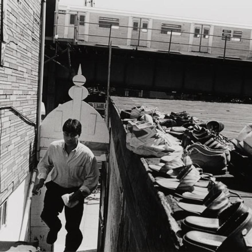 A man climbing stairs, pairs of shoes are nearby suggesting he is going to a mosque to pray