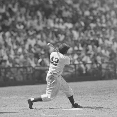 Jackie Robinson stands ready to bat in a crowded stadium