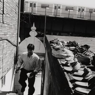 A man climbing stairs, pairs of shoes are nearby suggesting he is going to a mosque to pray