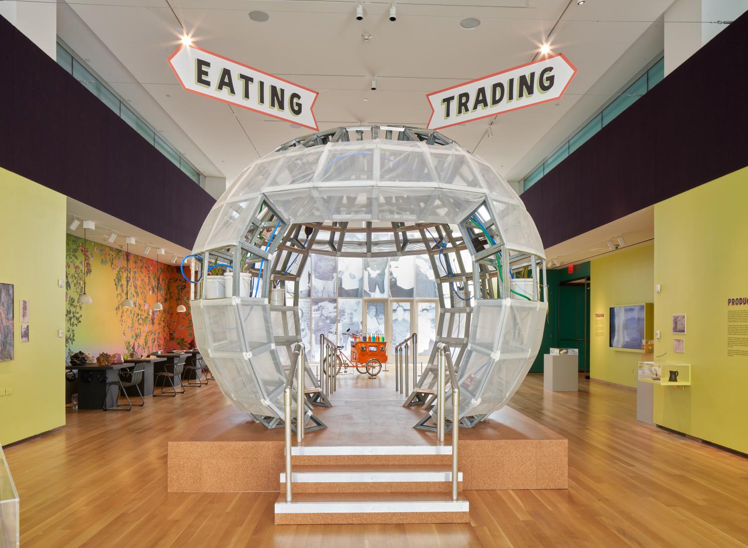 Uma grande esfera clara, semelhante a um globo de neve, fica no centro da imagem com placas que dizem 'comer' e 'negociar' acima dela.