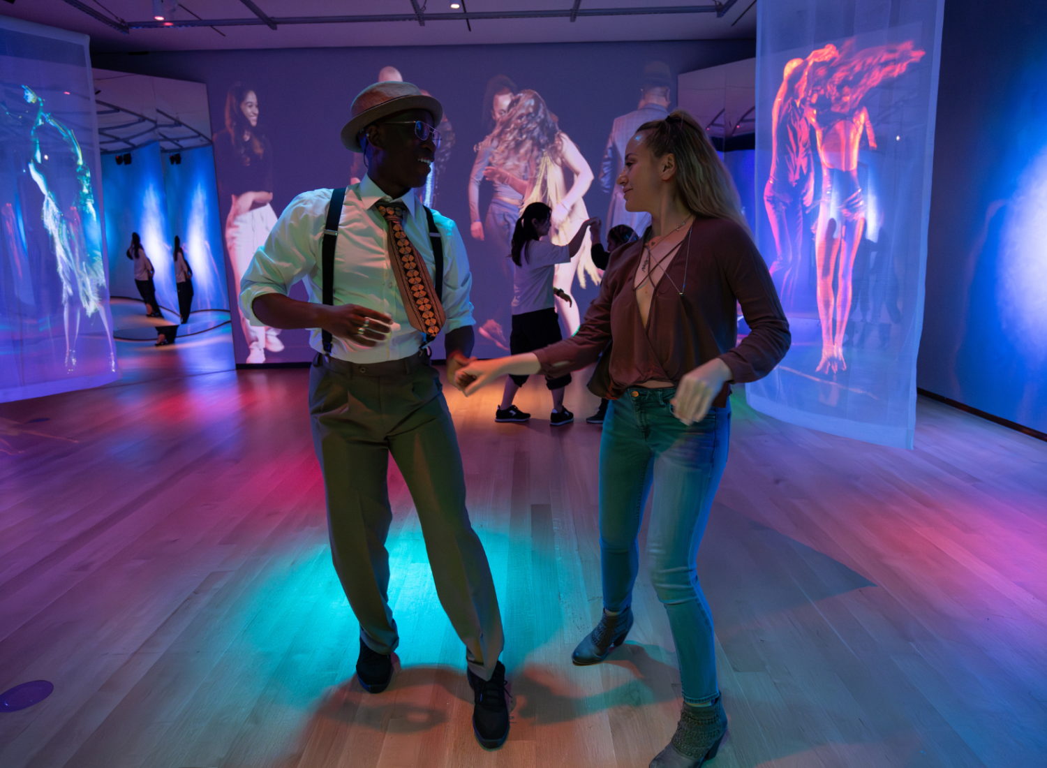 A man and woman smiling and dancing together on a disco dance floor