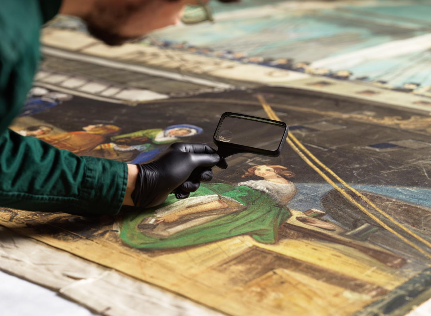 一名男子拿着放大镜仔细观察一幅画，画中画着一位身着绿色裙子的女人，旁边是一艘船。