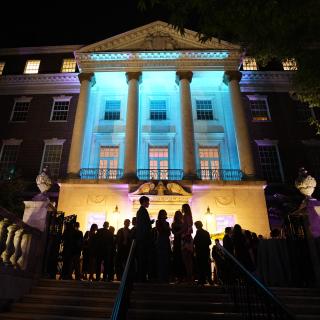 A fachada do Museu iluminada por luzes azuis à noite.