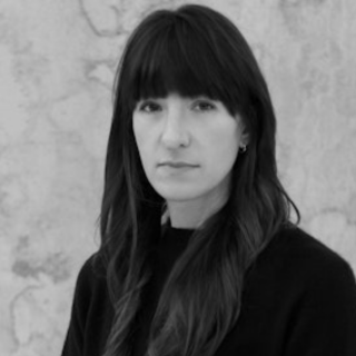 A woman with long brown hair in a black shirt 