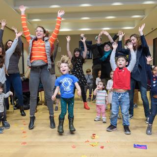 Un groupe d'adultes et d'enfants saute.