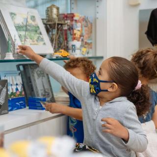 Une jeune fille attrape une petite statue de la Liberté.