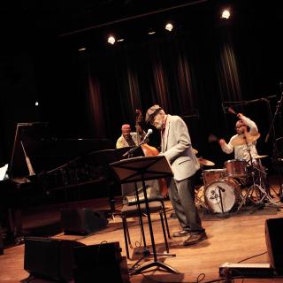 Poet Amiri Baraka performing with a group of jazz musicians on a stage