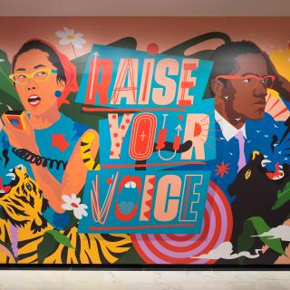 Photograph of the immersive installation "Raise Your Voice," original artwork of activists and allies Yuri Kochiyama and Malcolm X by artist Amanda Phingbodhipakkiya.