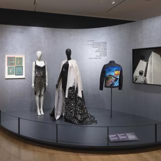 Three items of clothing are posed in a gallery.  
