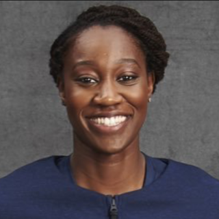 Tina Charles head shot - fond gris avec chemise bleue