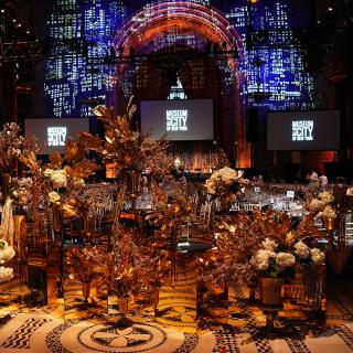 2025 Gotham Dreams Gala with tables in front of screens showing the MCNY logo