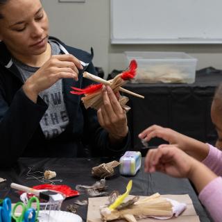 An adult and a child creating an artwork together.
