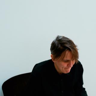 Photograph of someone dressed in black sitting in a chair