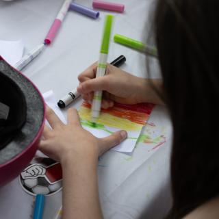 A child creating an artwork with markers.