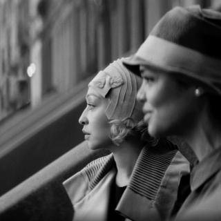 Imagem estática do filme Passagem de duas mulheres em uma varanda da cidade