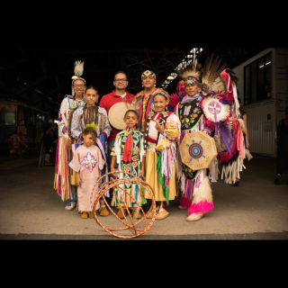 A group of adults and children in traditional clothing posing for a photo.