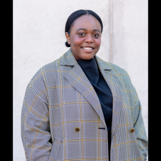A woman in a grey coat smiling