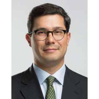 Photo of man in a green tie wearing glasses smiling