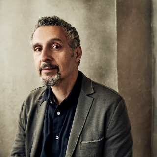 Image of actor John Turturro in front of grey background