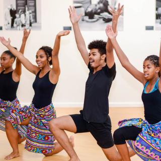 Image de quatre danseurs posant dans un studio de danse