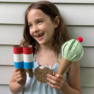 imagem de uma menina segurando sobremesas congeladas usando papel e materiais reciclados