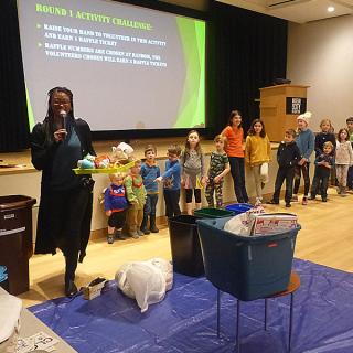 Photograph of participants separating waste into appropriate trash bins based on what recyclable material they are made from. 