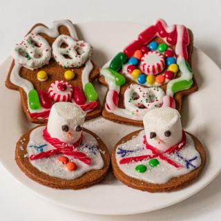 A display of an assortment of holiday cookies with decorations on a white plate