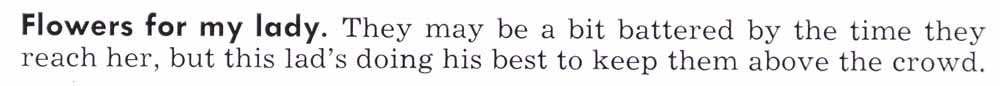 Flores para mi señora. Puede que estén un poco maltratados cuando la alcancen, pero este muchacho está haciendo todo lo posible para mantenerlos por encima de la multitud.
