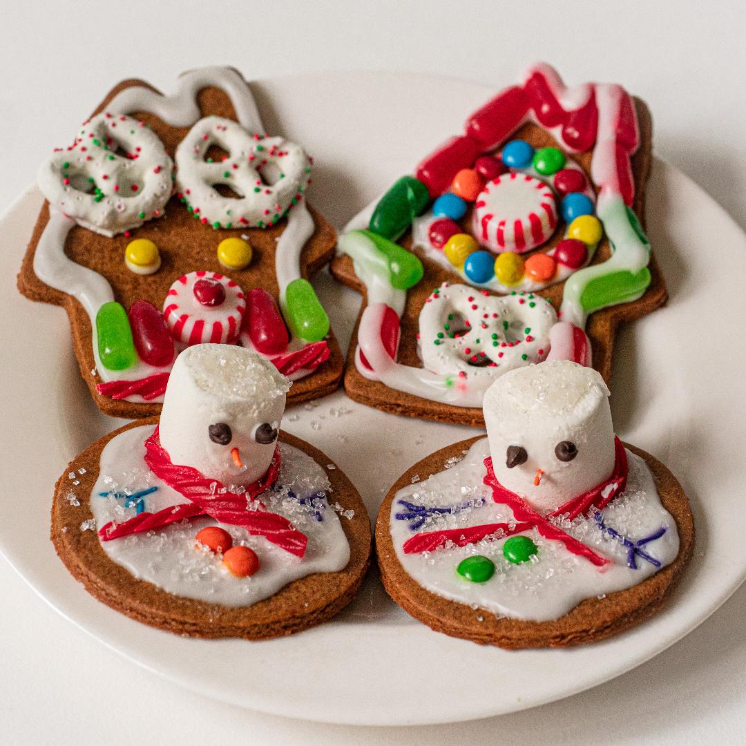 A display of an assortment of holiday cookies with decorations on a white plate