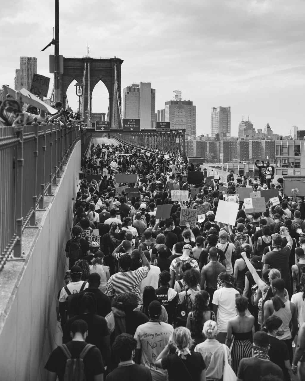 Fotografía en blanco y negro de manifestantes cruzando el Puente de Brooklyn