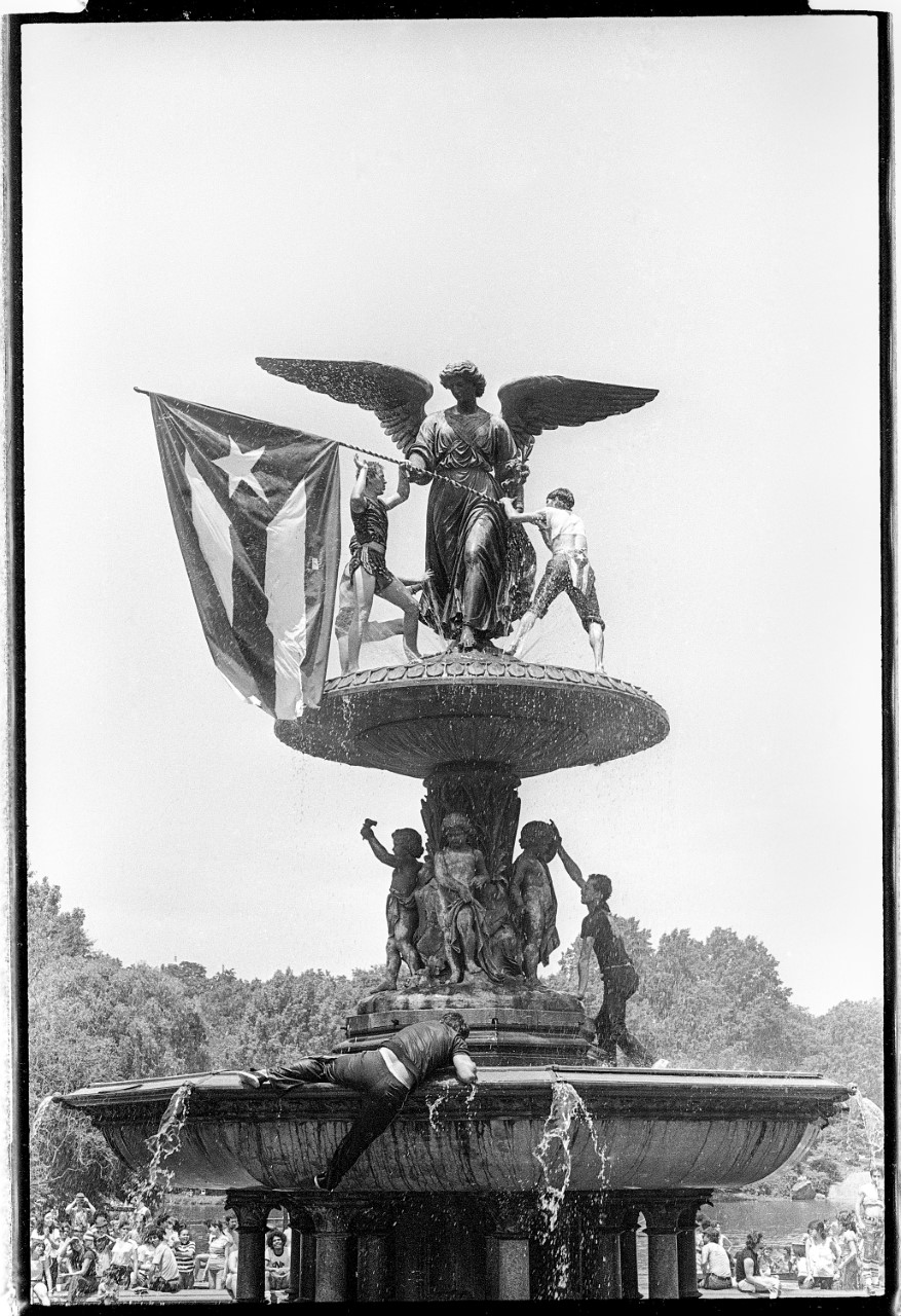 A fountain with a statue holding the Puerto Rican flag