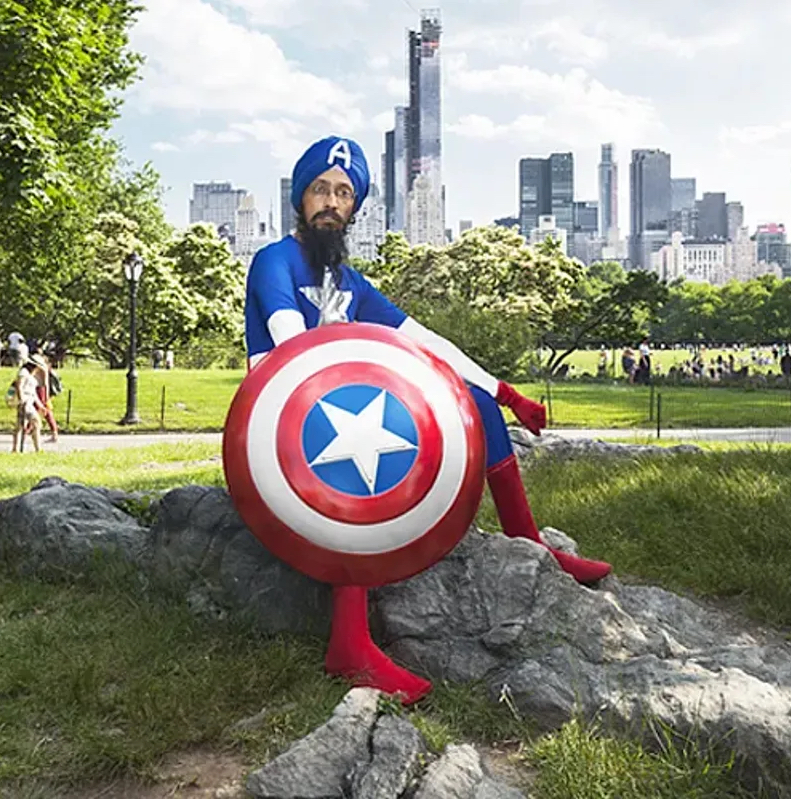 Um homem com turbante tradicional e uniforme do Capitão América posa no Central Park.